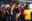 Das Foto zeigt ein Crew-Mitglied von SOS Humanity, das ein gerettetes Kind auf dem Arm trägt.