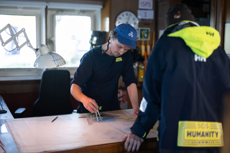 First officer is studying a map in the bridge of Humanity 1.