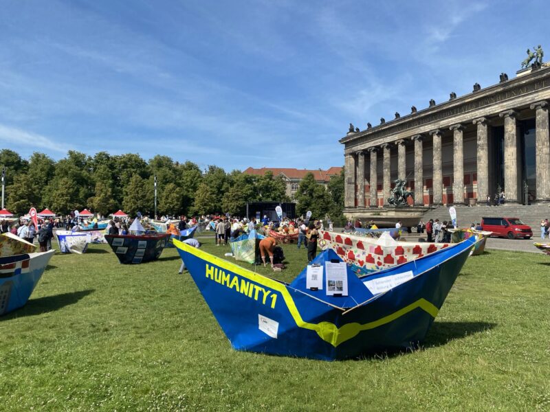 Überdimensionales Faltboot auf einer Wiese