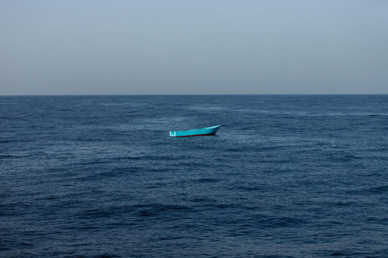 leeres kleines blaues Flüchtlingsboot inmitten eines Sturms auf dem zentralen Mittelmeer