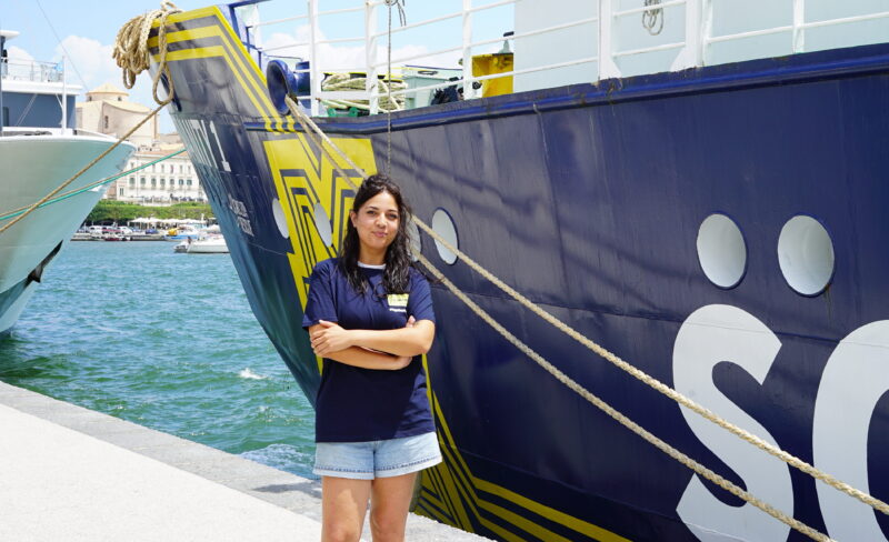 Logistikerin Federica vor dem Rettungsschiff Humanity 1 im Hafen von Syrakus