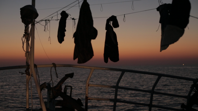 Still aus dem Film „Strange Fish“, den SOS Humanity bei einer Filmvorführung zeigen wird: An Deck eines Fischerbootes hängen Klamotten zum Trocknen.