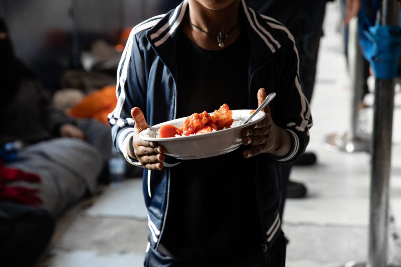 Ein Überlebender mit einem Teller warmen Essen.