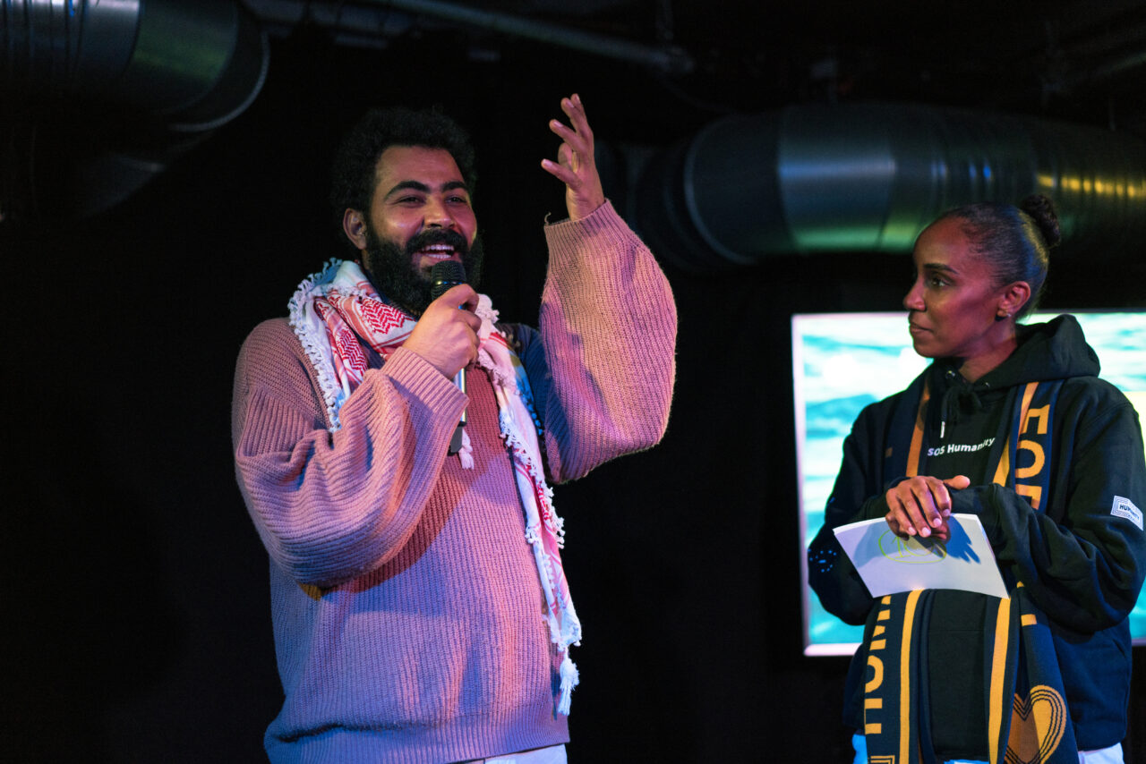 Moderatorin Hadnet Tesfai interviewt Tarek Elmasoudi von "Über den Tellerrand" auf der Bühne im FluxBau.