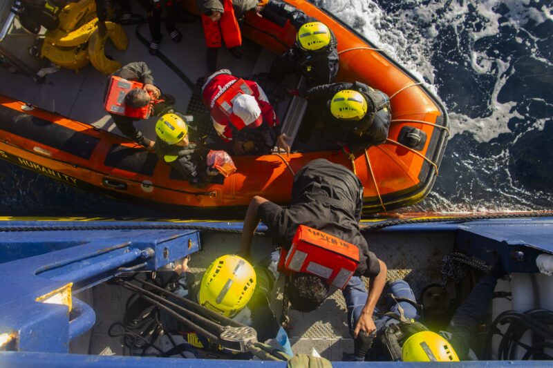 Vogelperspektive auf den Umstieg von RHIB auf SOS Humanity / Drohne shot of people moving from RHIB to SOS Humanity